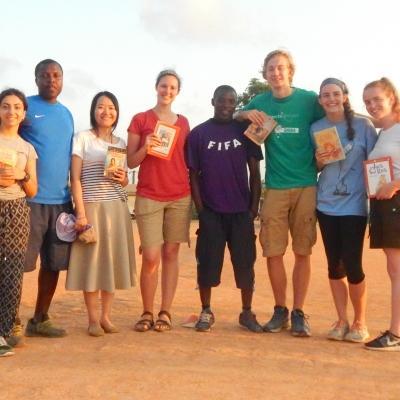 Volunteers who teamed up to do childcare work in Ghana pose for a photo at their placement. As part of their community work in Ghana, Projects Abroad volunteers on a Team Trip read books with children at their placement.